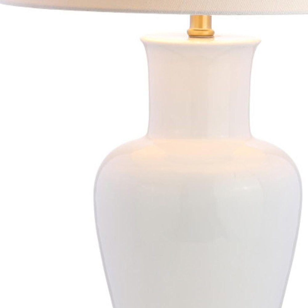 29" Gold Urn Table Lamp With Drum Shade. Table lamp isolated on a plain white background.