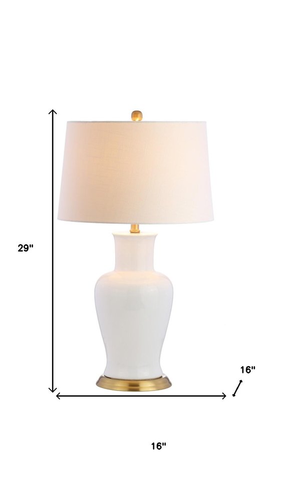 29" Gold Urn Table Lamp With Drum Shade. Table lamp isolated on a plain white background.