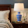 29" Blue Gold And Beige Urn Bedside Lamp With Empire Shade shown outdoors on an outdoor setting.