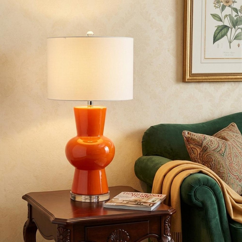29" Clear Novelty Table Lamp With Drum Shade displayed on a tabletop in a furnished interior against a cream wall.