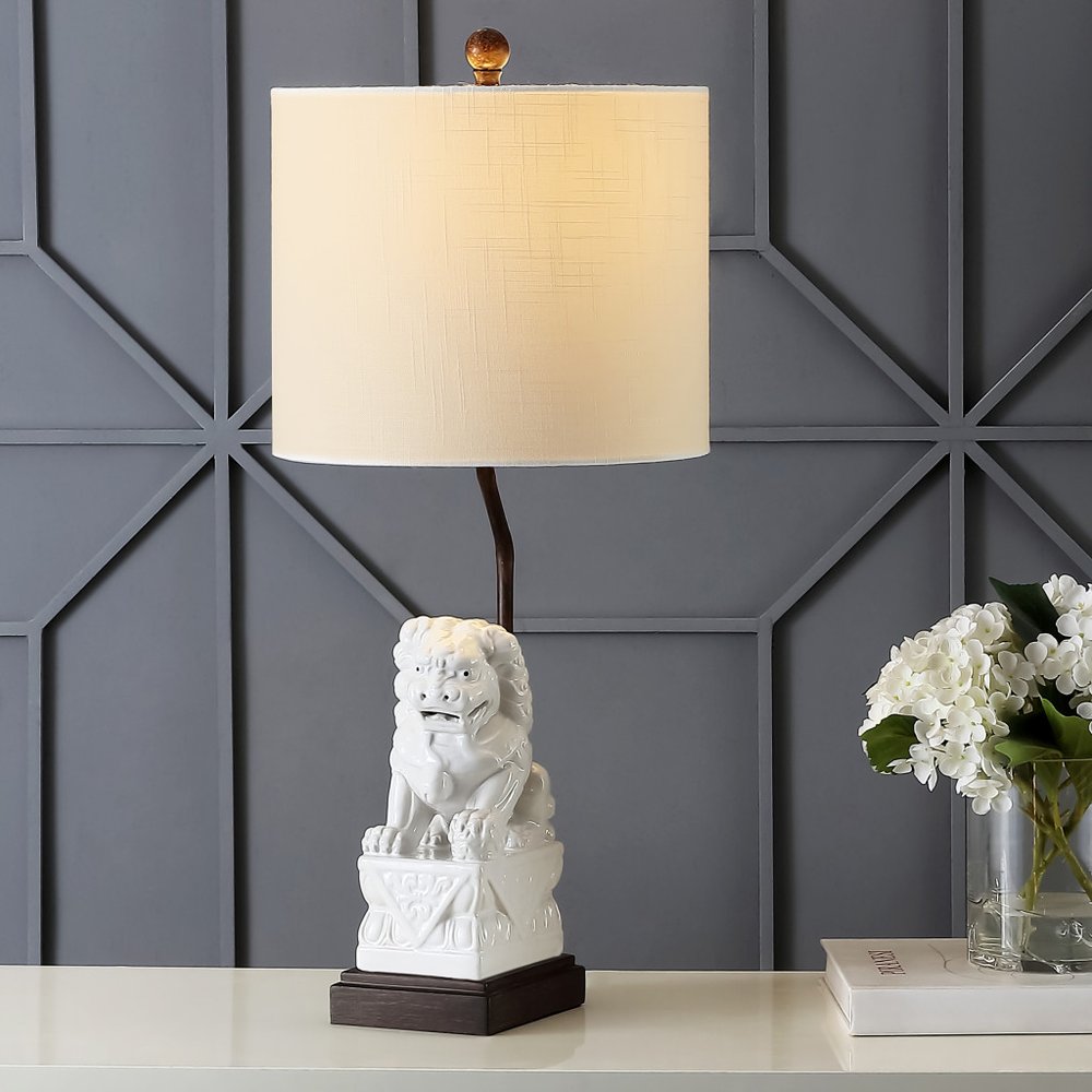 28" Brown Novelty Table Lamp With Globe Shade displayed on a tabletop in a furnished interior against a gray wall.