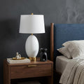 27" Gold Novelty Table Lamp With Empire Shade displayed on a tabletop in a furnished interior against a dark wall.