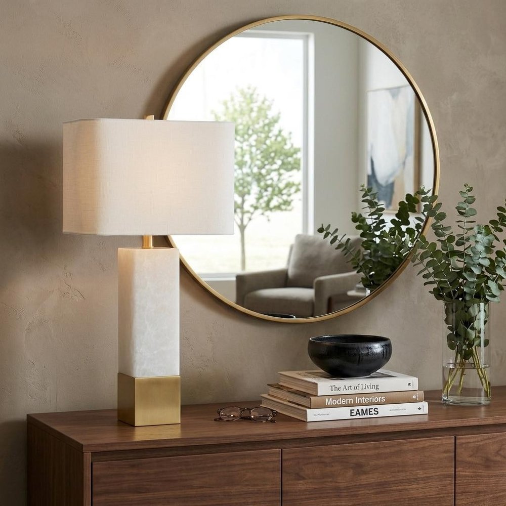 29" Gold Novelty Table Lamp With Shade displayed on a dark wood tabletop in a furnished interior against a tan wall.