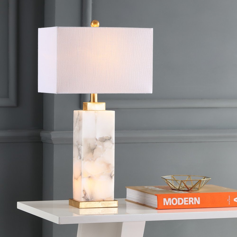 28" Gold Novelty Table Lamp With Shade displayed on a tabletop in a furnished interior against a gray wall.
