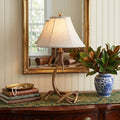 28" Brown Novelty Table Lamp With Globe Shade displayed on a tabletop in a furnished interior against a tan wall.
