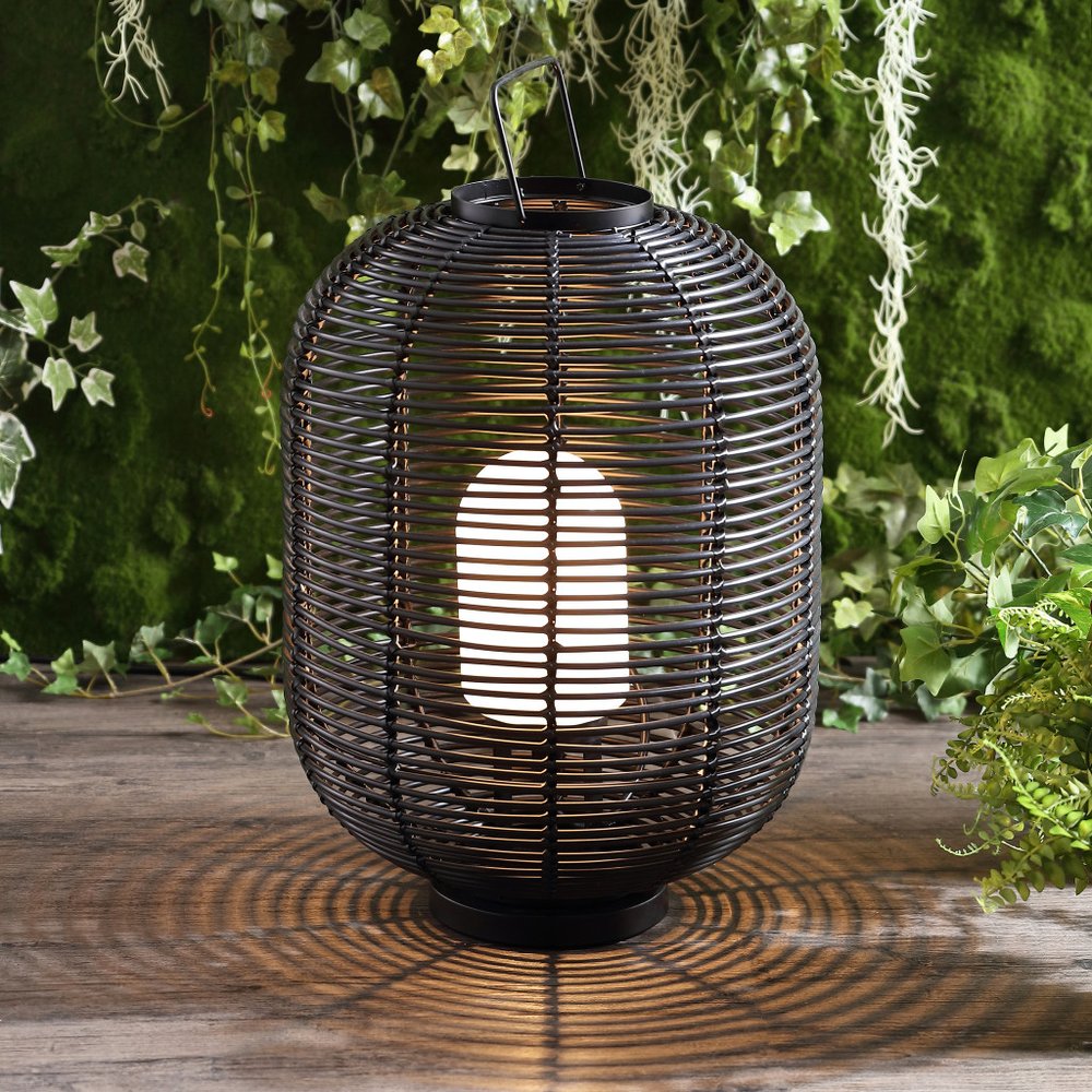 27" Black Novelty Lantern shown outdoors on an outdoor setting with greenery.