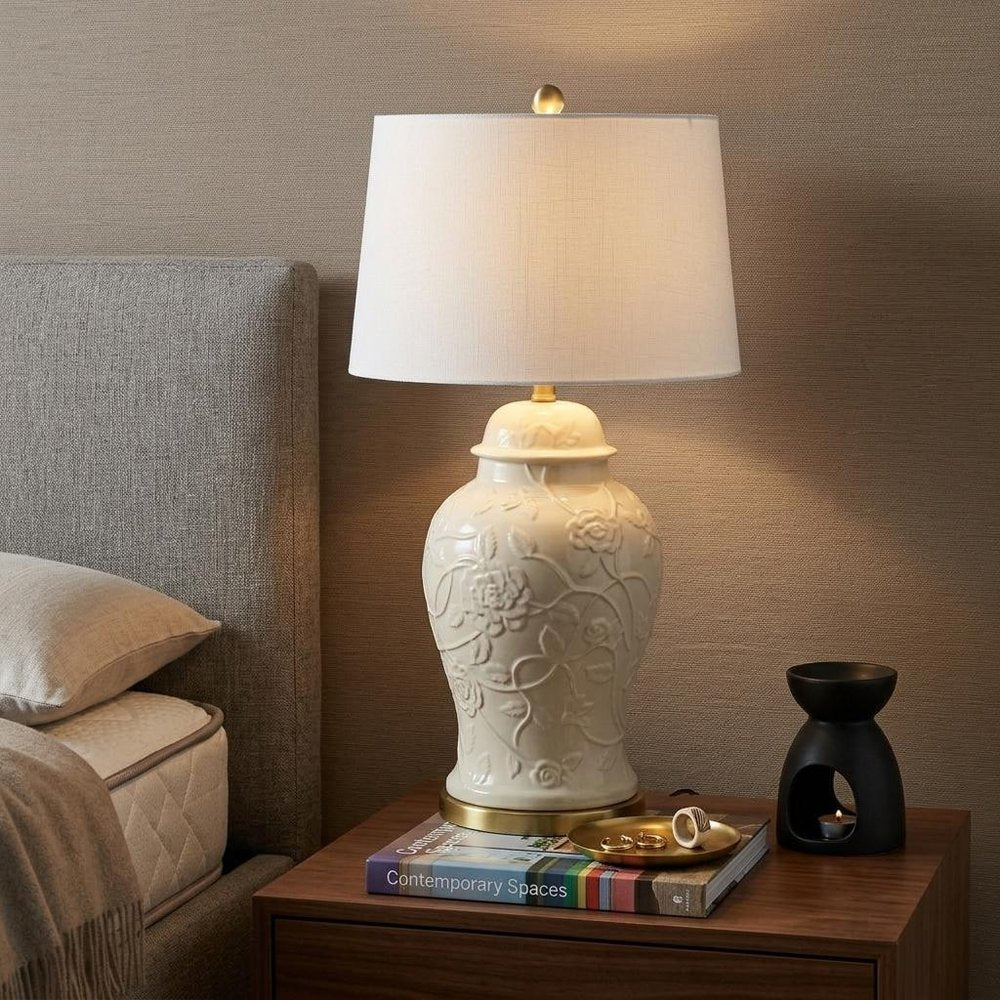 30" Gold Novelty Table Lamp With Empire Shade displayed on a dark wood tabletop in a furnished interior against a tan wall.