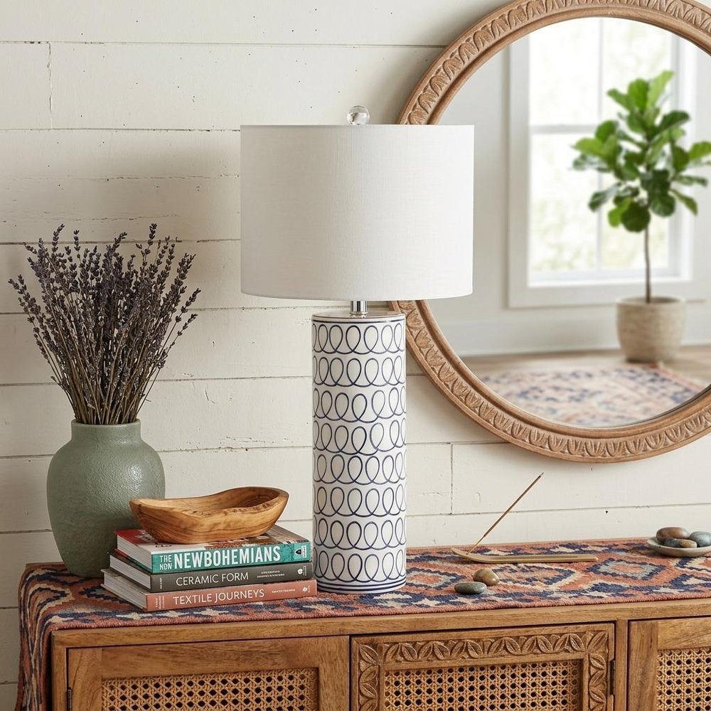 29" White Table Lamp With Drum Shade displayed on a dark wood tabletop in a furnished interior against an off-white wall.