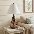 26" Dark Brown Antlers Table Lamp With Empire Shade displayed on a wood tabletop in a furnished interior against a cream wall.
