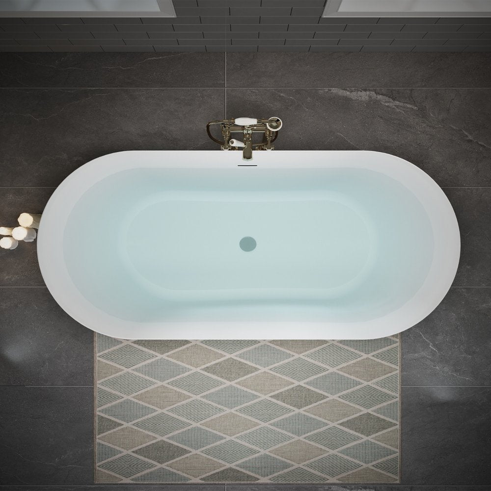 Top view of a white acrylic oval bathtub filled with water, with a vintage-style faucet and a diamond-patterned rug on a dark tiled floor.