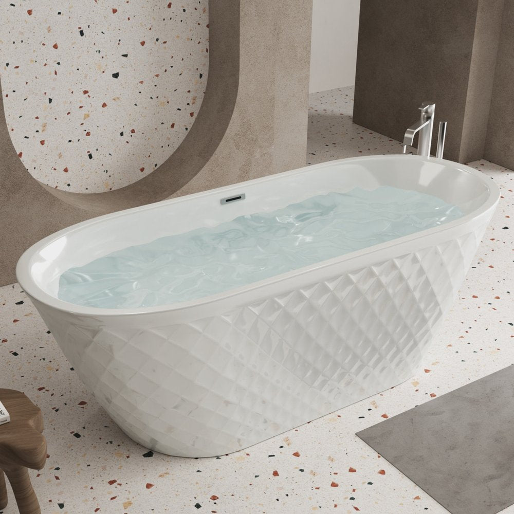 White acrylic oval bathtub with textured exterior filled with water, set on a terrazzo floor with a modern architectural background.