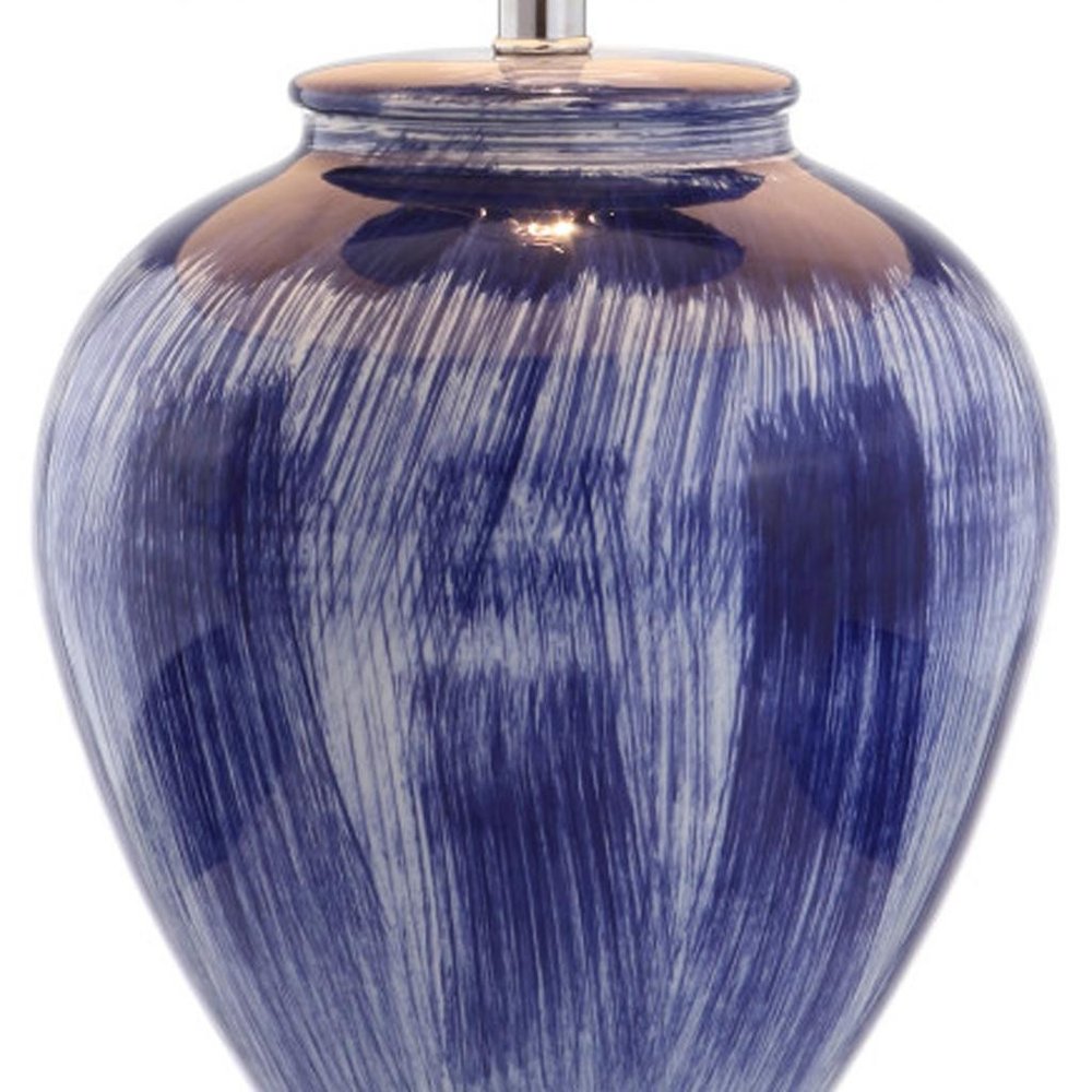 26" Blue And Clear Urn Table Lamp With Drum Shade. Table lamp isolated on a plain white background, showing its blue color.
