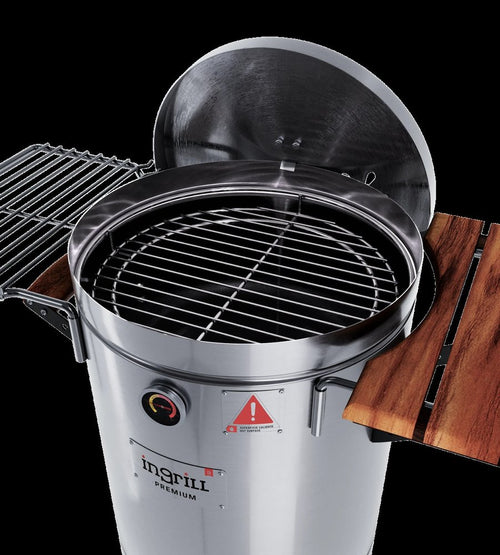 Silver stainless steel portable smoker barrel with open lid, grill grate, and wooden side shelves against a black background.