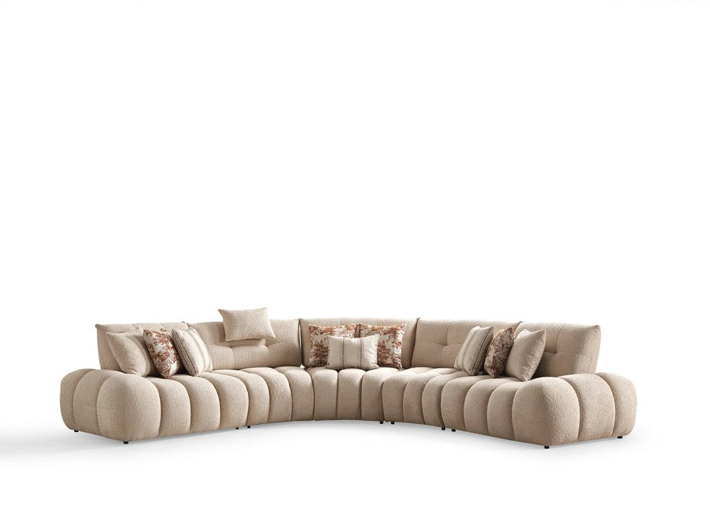 Taupe boucle curved sectional sofa with decorative pillows on a white background.