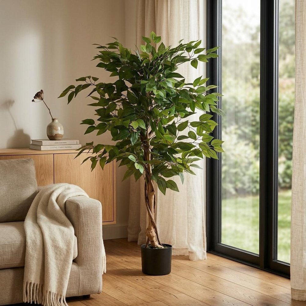 47" Green Artificial Ficus Tree In Cylindrical Black Pot styled in a furnished interior with a tan wall on a wood floor.