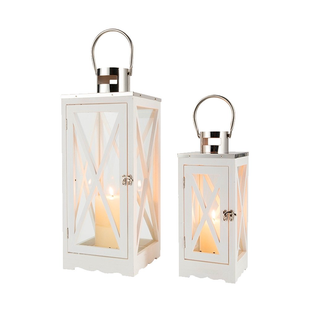 Set of two white wood and glass lanterns with metal handles, each holding a lit candle.
