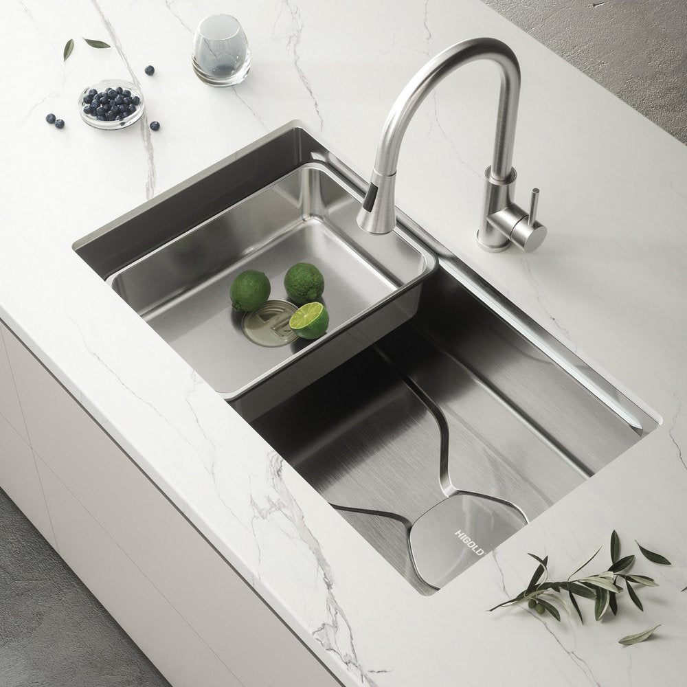 Silver stainless steel undermount kitchen sink with a faucet, limes, and blueberries on a marble countertop.