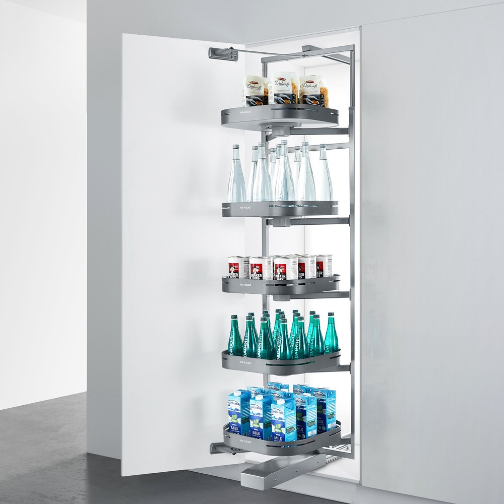 Silver stainless steel pull-out pantry organizer with shelves holding bottles, cans, cartons, and pasta in a white kitchen.