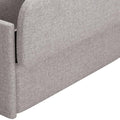 Close-up of a gray fabric upholstered storage bench with a flip top, showing the textured material and a corner of the bench.