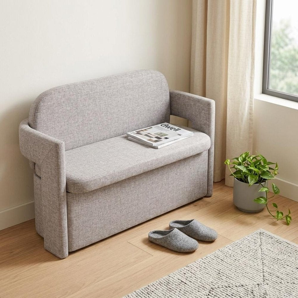 55" Gray Fabric Upholstered Storage Bench With Flip Top styled in a furnished interior with an off-white wall on a wood floor.
