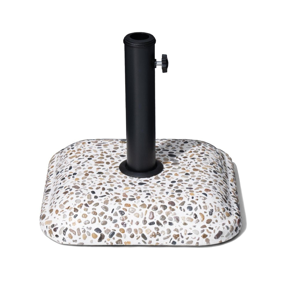 A black steel umbrella pole stands in a square, white base with a speckled pebble finish on a white background.
