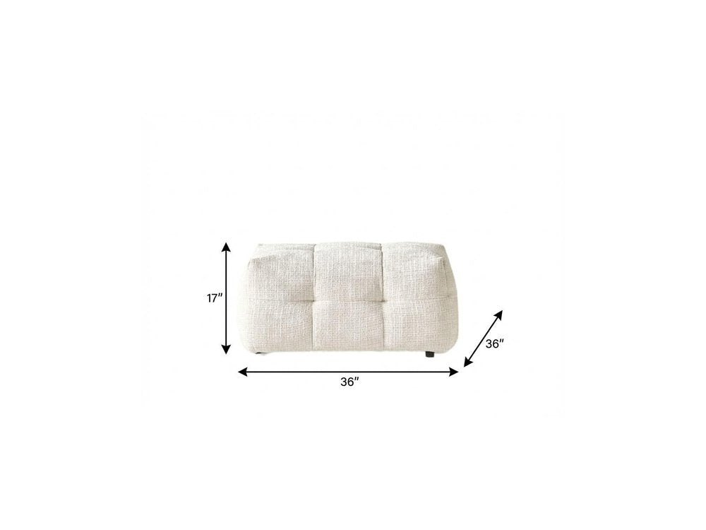 36" Beige and Black Chenille Tufted Pouf Ottoman. Ottoman isolated on a plain white background, showing its beige color.