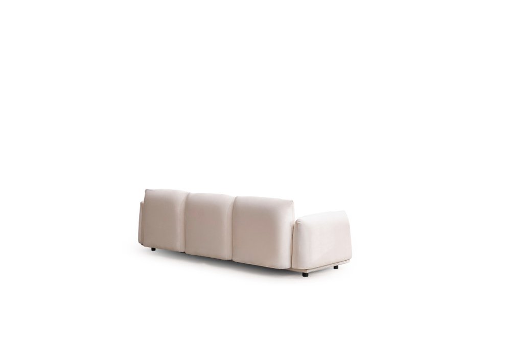 A white velvet sofa with four cushioned seats and a single armrest, shown from the back on a white background.