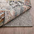 9' x 12' Gray Non Slip Rug Pad styled in a furnished interior with a light gray wall on a wood floor.