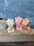 4" Natural Unscented Dimensional Female Form Candle shown outdoors on an outdoor setting in tan.