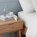 6" Light Blue Ocean Breeze Scented Soy Wax Candle In White Resin Novelty Holder shown outdoors on an outdoor setting.