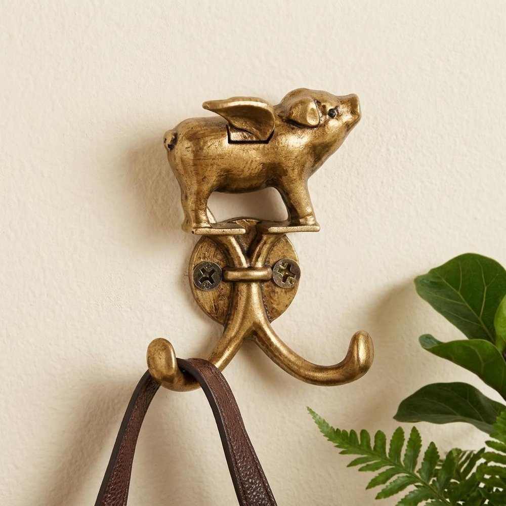 Two Hook 2" Antiqued Gold Cast Iron Pig Wall Hooks in a home interior