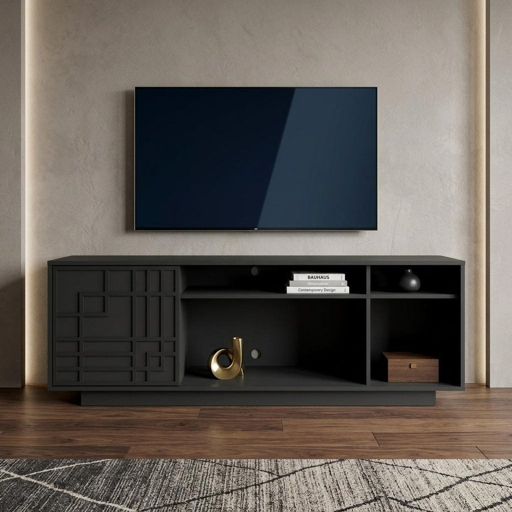 63" Black Carved Geometric Wood Enclosed and Open Storage TV Stand styled in a furnished interior with a tan wall on a dark wood floor.