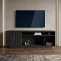 63" Black Carved Geometric Wood Enclosed and Open Storage TV Stand styled in a furnished interior with a tan wall on a dark wood floor.