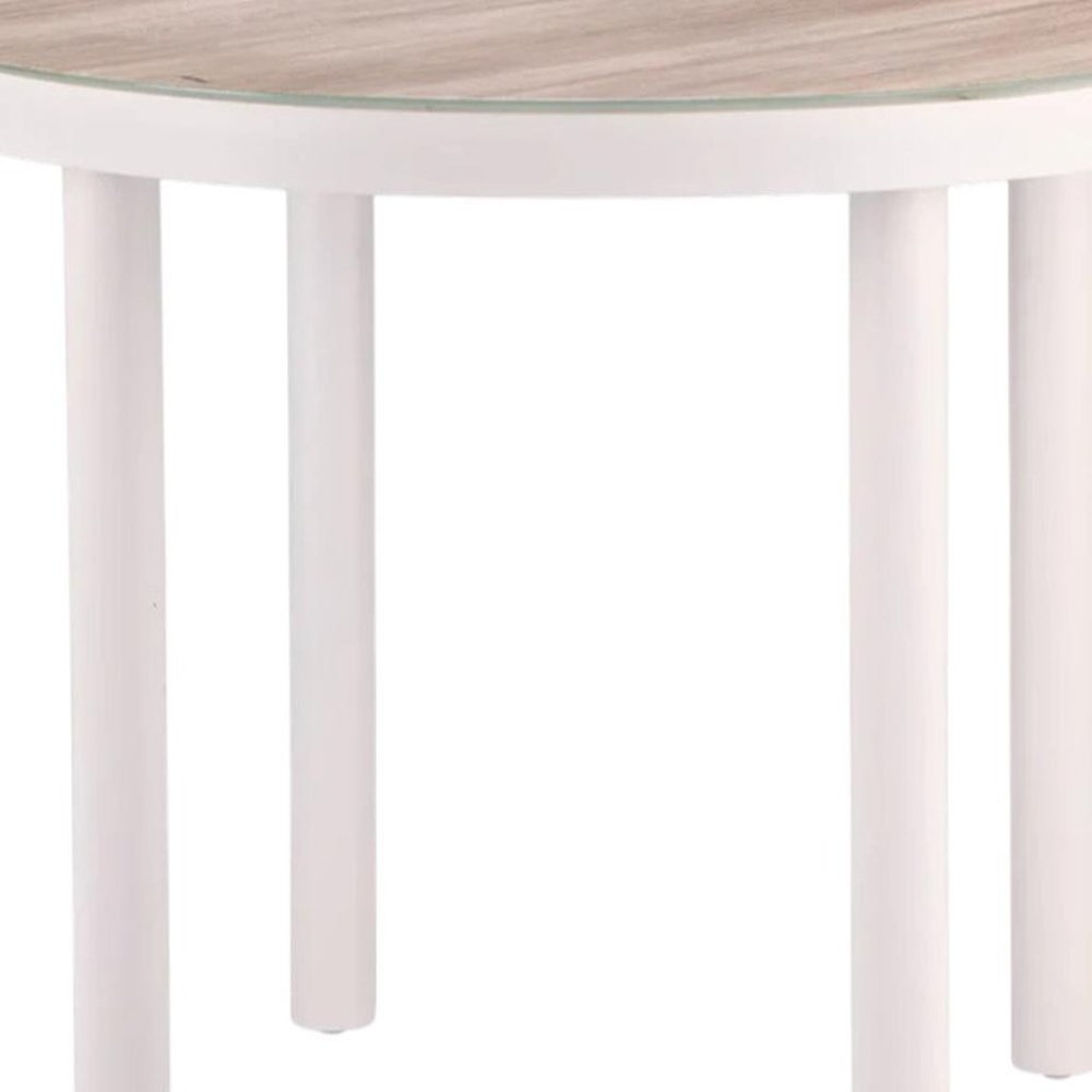 Round outdoor dining table with a natural wood-look top, white aluminum legs, and a glass accent.