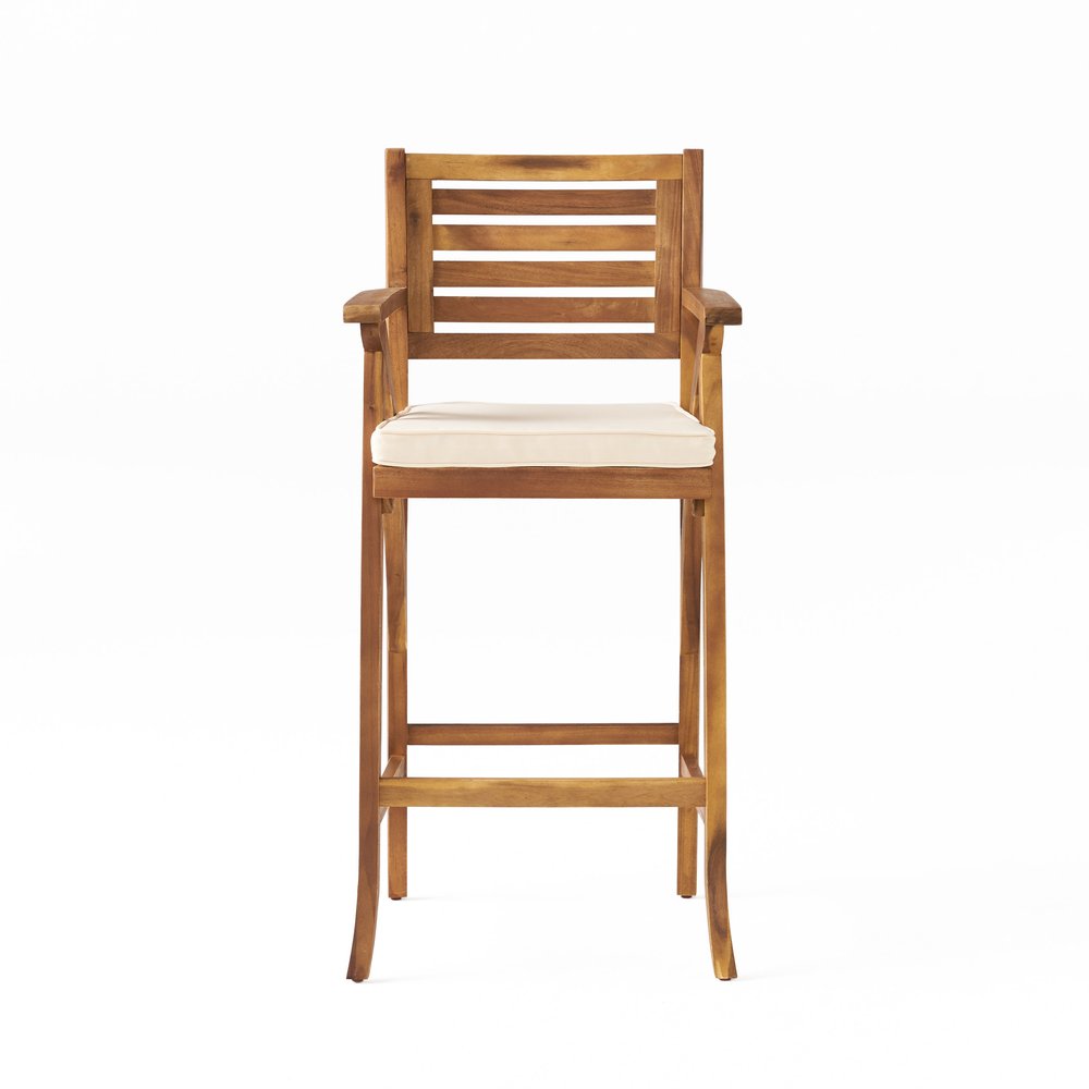 Natural solid wood outdoor bar height chair with a cream cushion on a white background.
