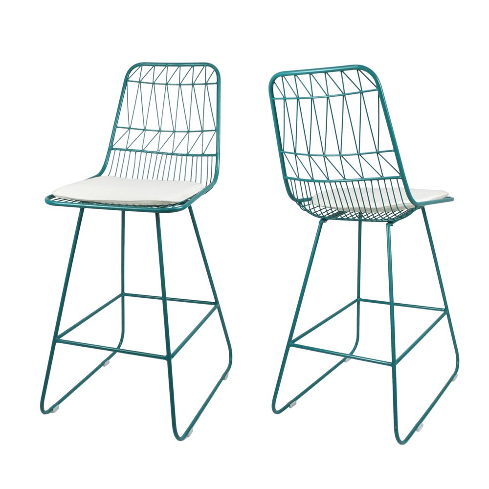 Two teal blue wireframe bar stools with white cushions on a white background.