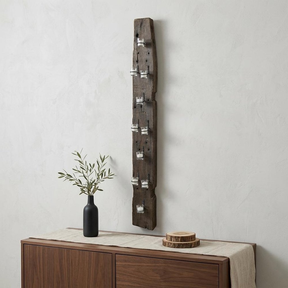 66" Brown Metal Hurricane Candle Holder displayed on a dark wood tabletop in a furnished interior against an off-white wall.