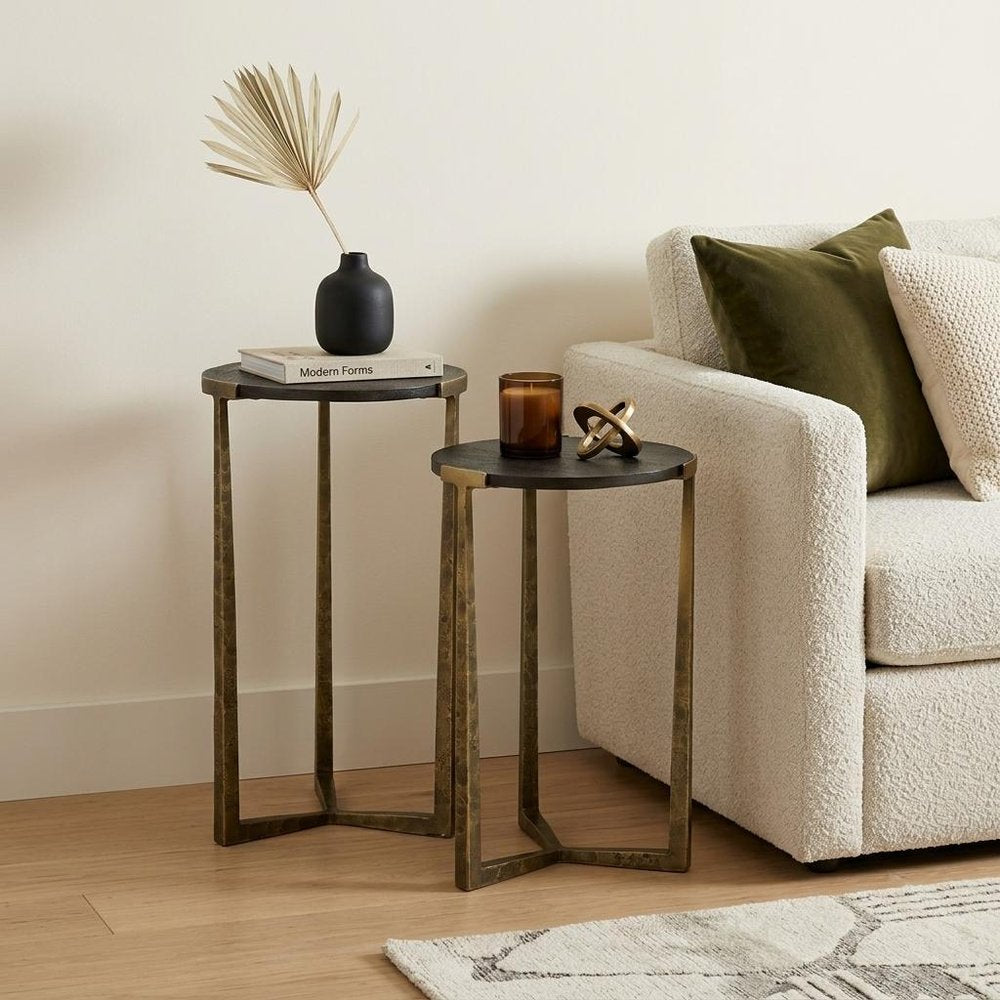 Set of Two Black and Antiqued Gold Distressed Solid Wood and Iron Round Cross Legs Nested Tables in a home interior