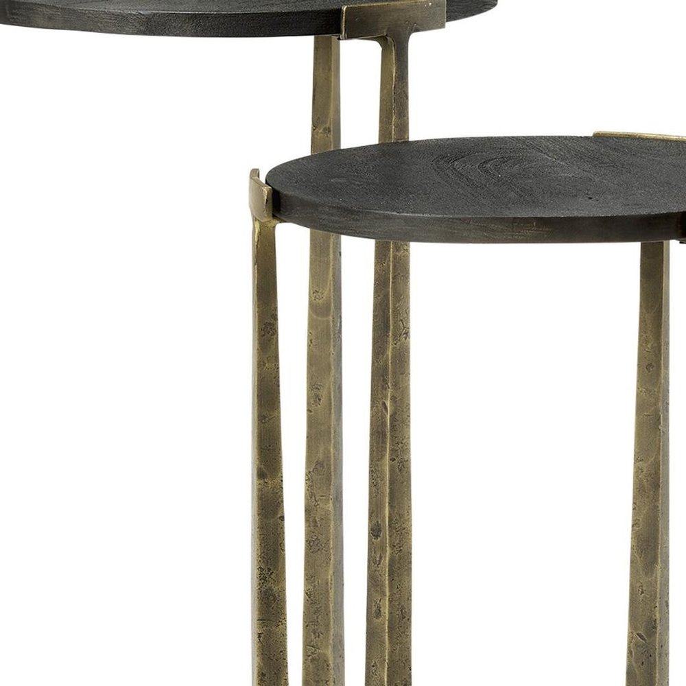 Set of Two Black and Antiqued Gold Distressed Solid Wood and Iron Round Cross Legs Nested Tables on a white background