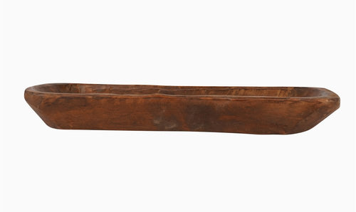A long, narrow, rustic brown solid wood oval dough bowl on a white background.