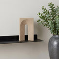 10" Beige Resin Tabletop Sculpture styled in a furnished interior with an off-white wall on a tiled floor.
