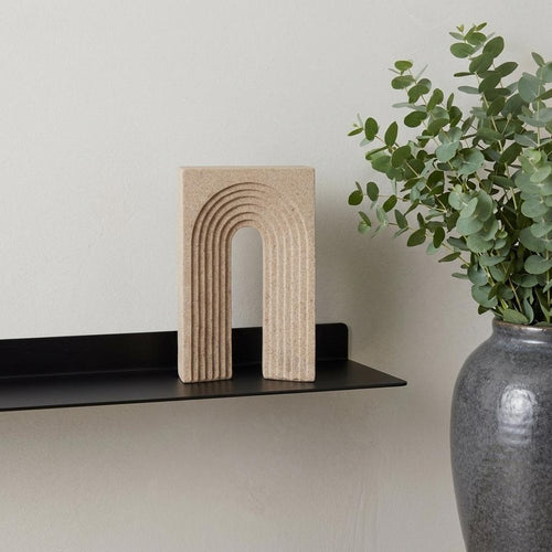 10" Beige Resin Tabletop Sculpture styled in a furnished interior with an off-white wall on a tiled floor.