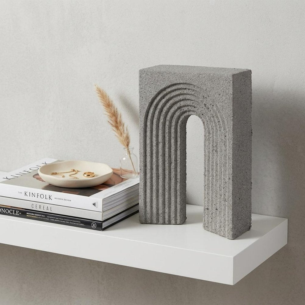10" Gray Resin Tabletop Sculpture styled in a furnished interior with an off-white wall on a wood floor.