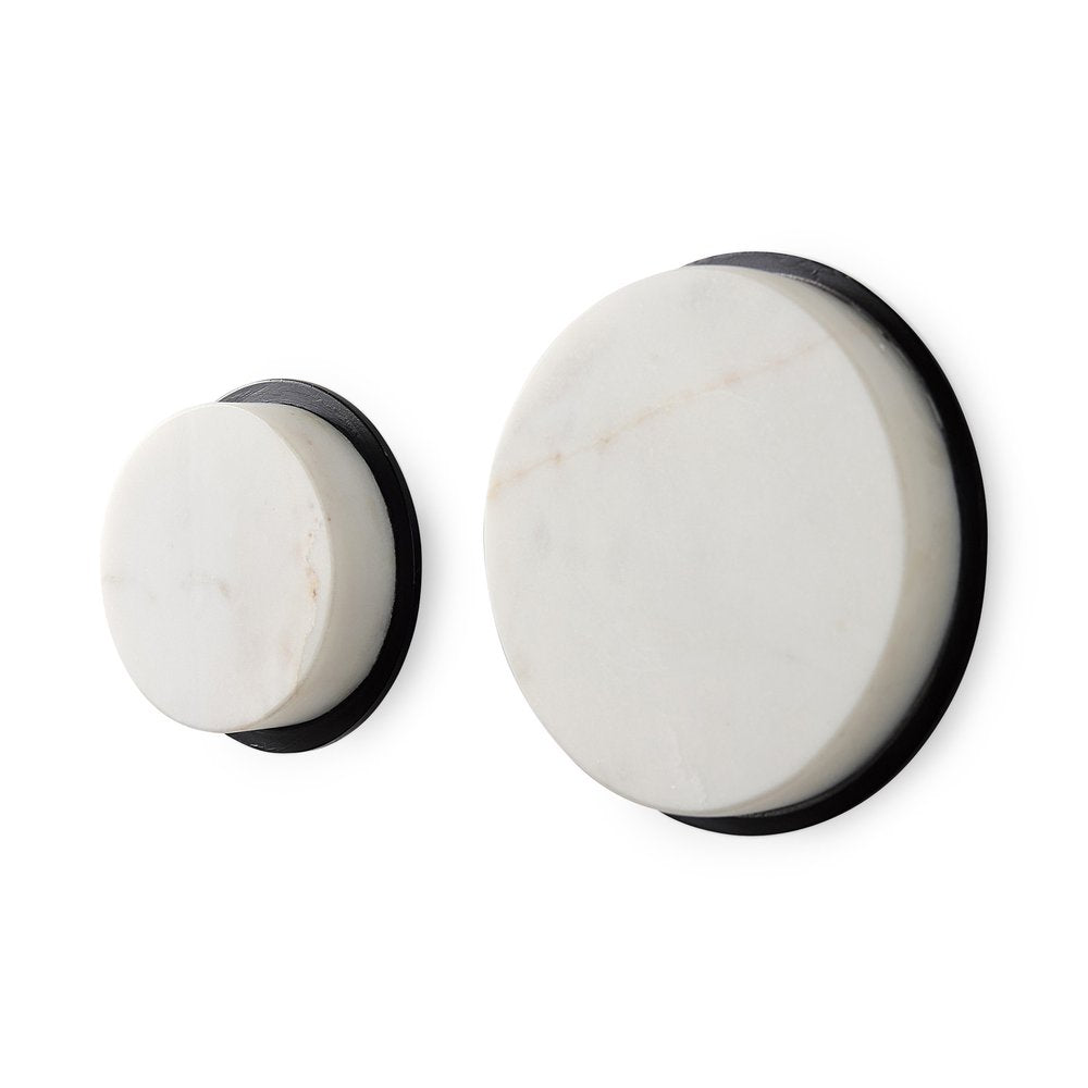 Two white marble sphere decorative wall sculptures with black bases on a white background.