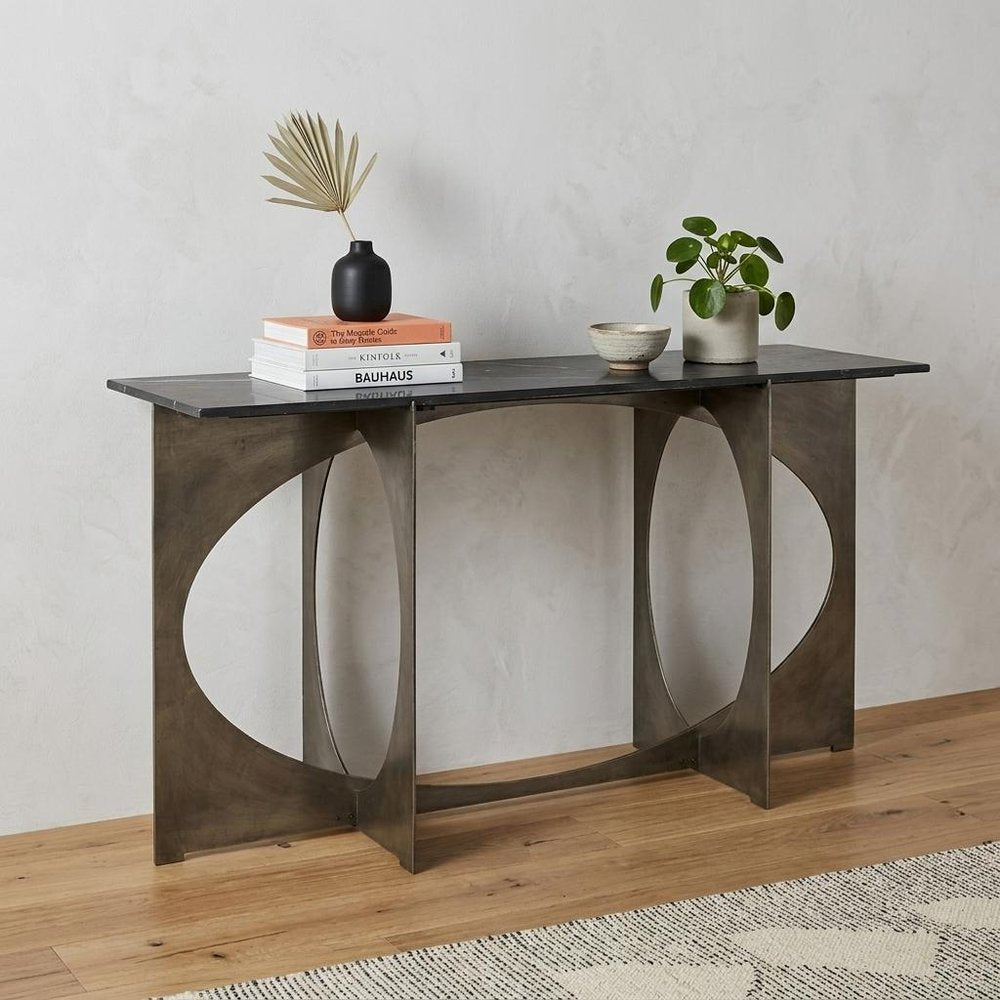60" Black and Nickel Genuine Marble and Metal Frame Console Table styled in a furnished interior with a light gray wall on a wood floor in silver marble.
