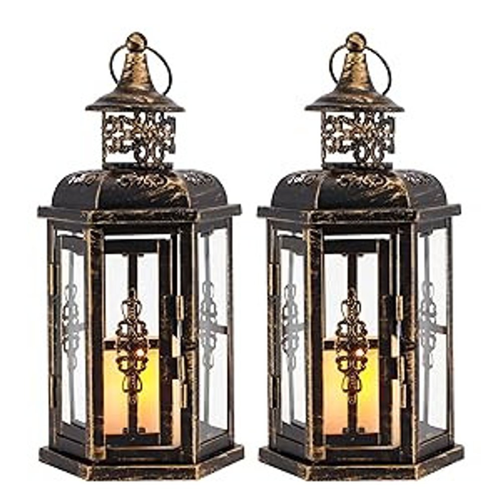 Two black and gold hexagonal lanterns with glass panels and LED candles inside, set against a white background.