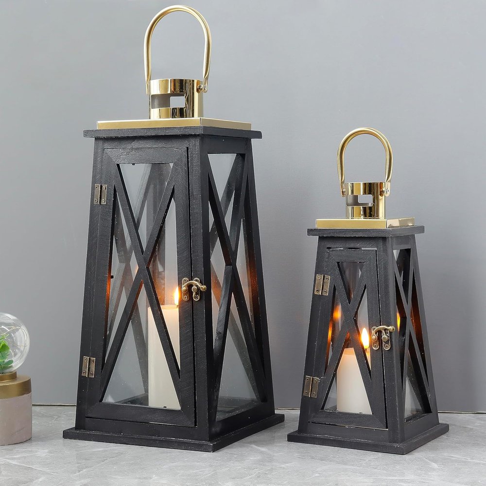 Two black distressed wood and glass tabletop lantern candle holders with gold accents on a gray background.