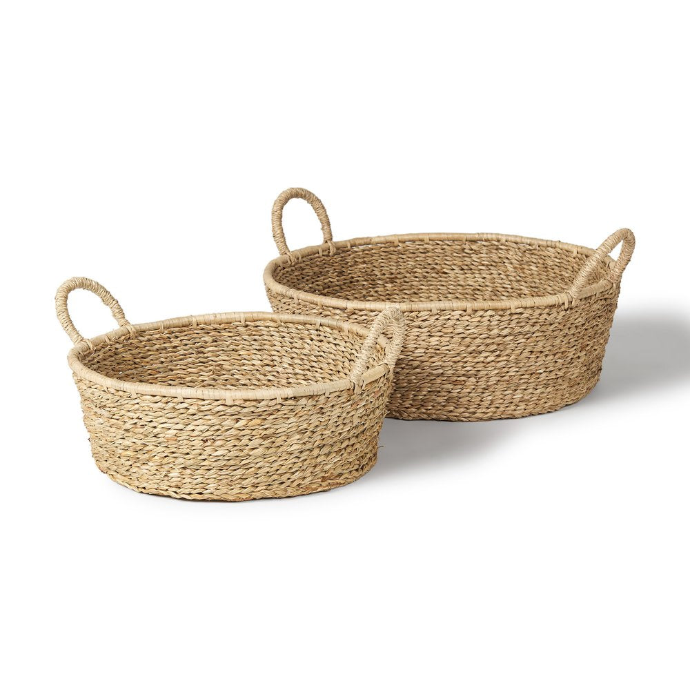 Two oval brown seagrass baskets with handles on a white background.