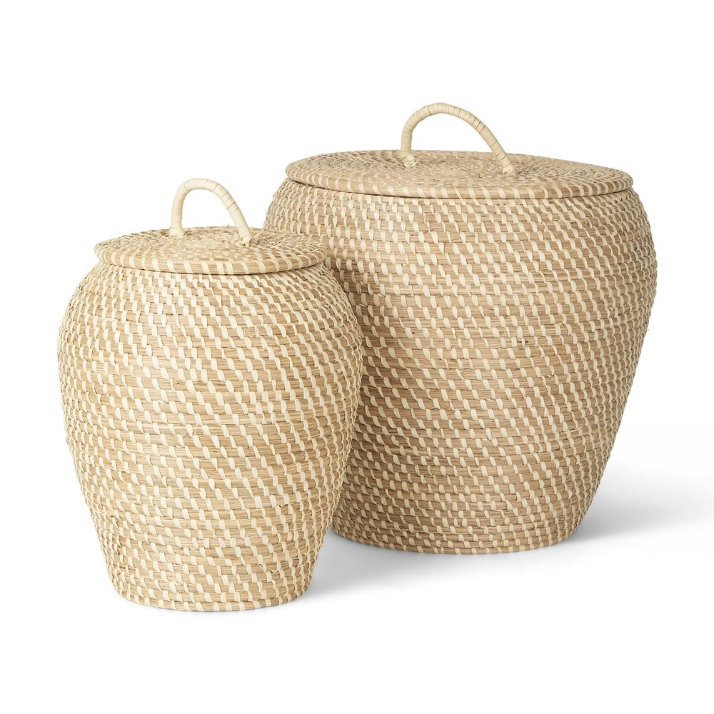 Two woven seagrass baskets with lids and handles on a white background.