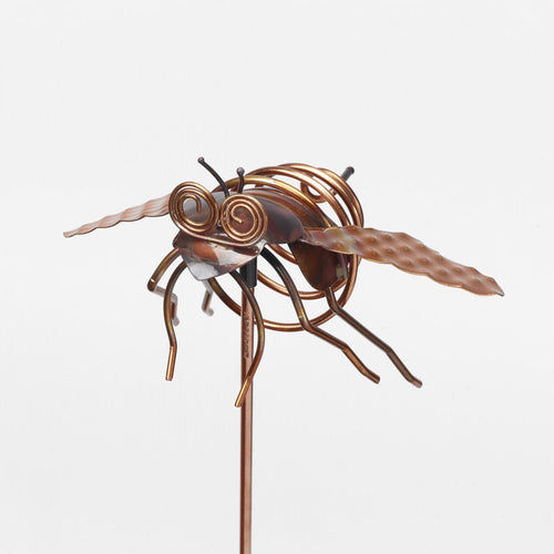 Copper insect garden stake with coiled wire wings and eyes on a white background.